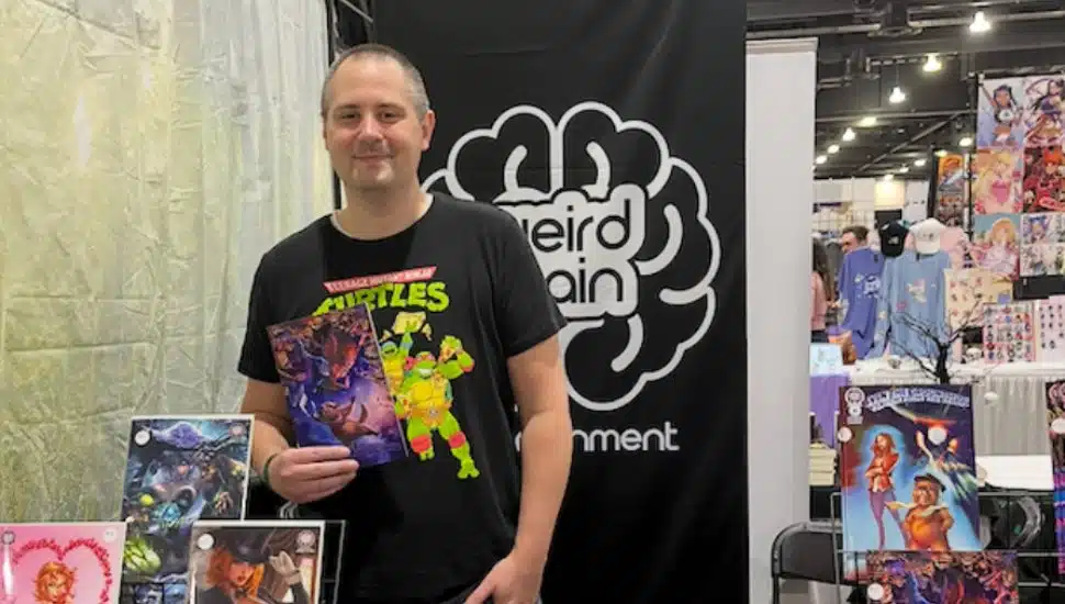 Dave Franchini stands at the Weird Brain Entertainment table at a comic book convention.