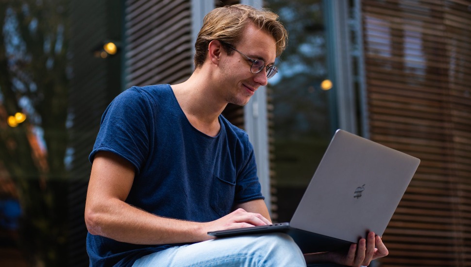 man on computer for desales MBA program