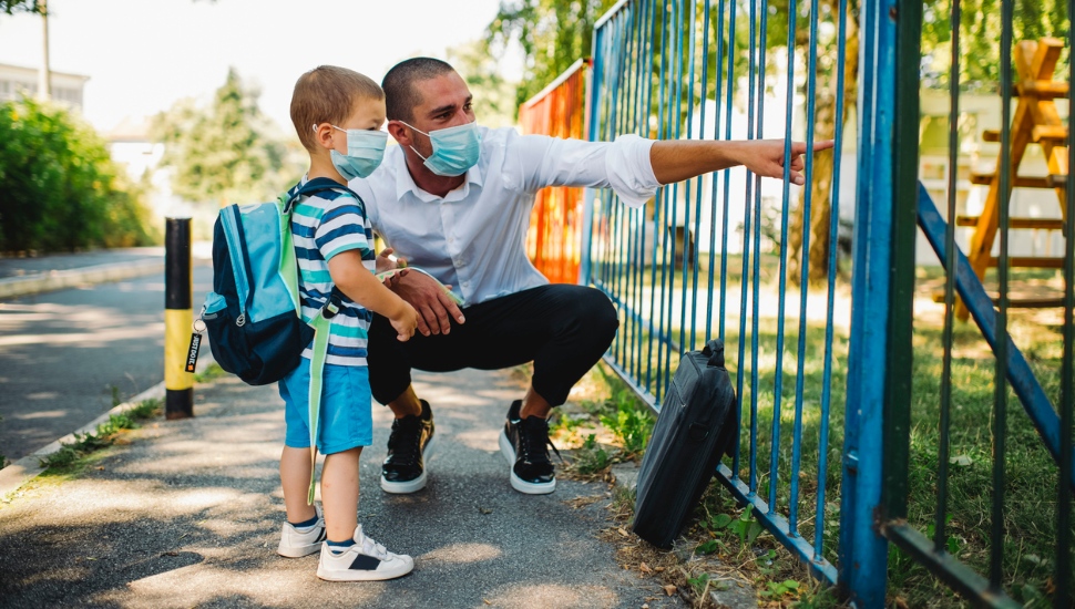 Dad and his young son outside a playground.