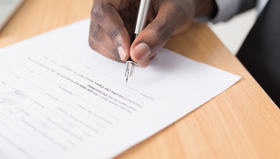 man signing a piece of paper
