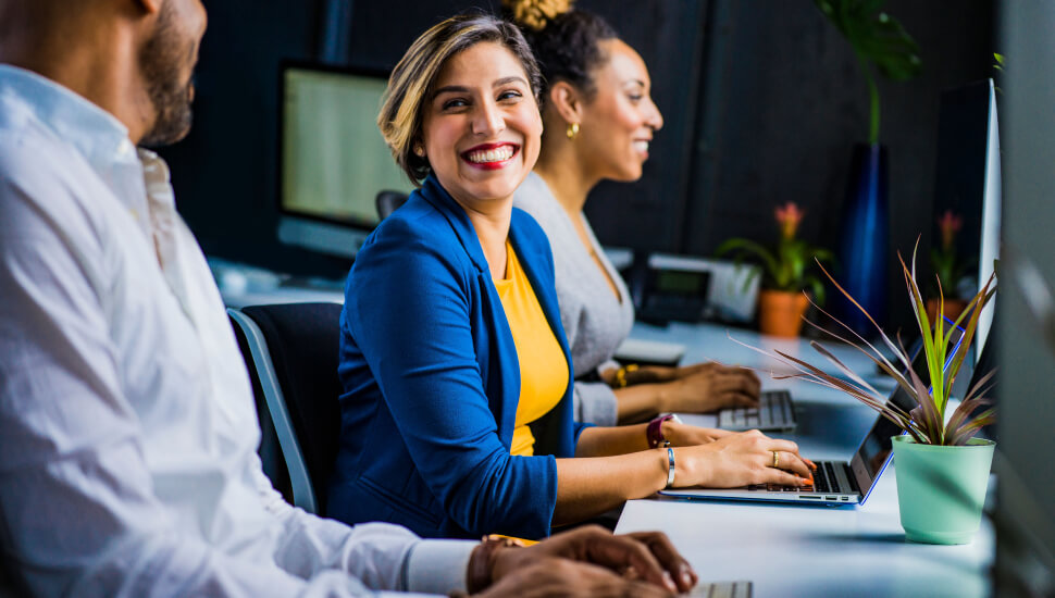 Three People sitting at a conference room table.