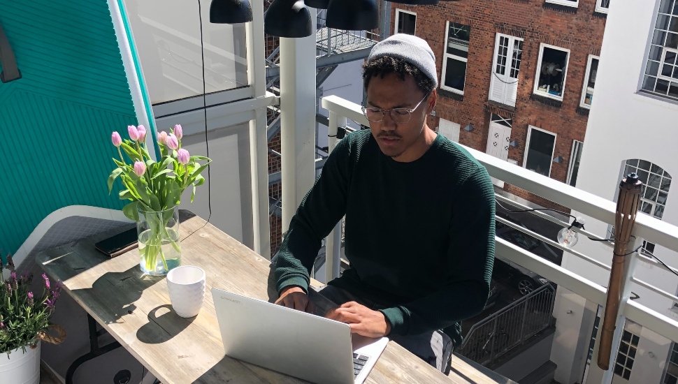 man on rooftop on computer