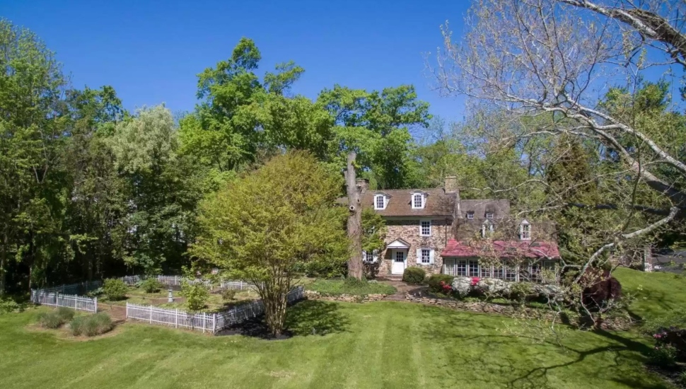 stone house with white-fenced garden