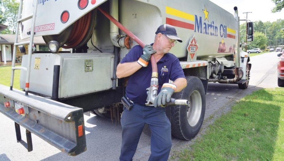 man pulling a hose from a truck