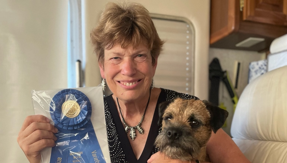 woman holding ribbon and a dog