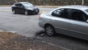 car hitting a hole in the road