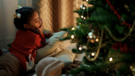 Little girl by a Christmas Tree.