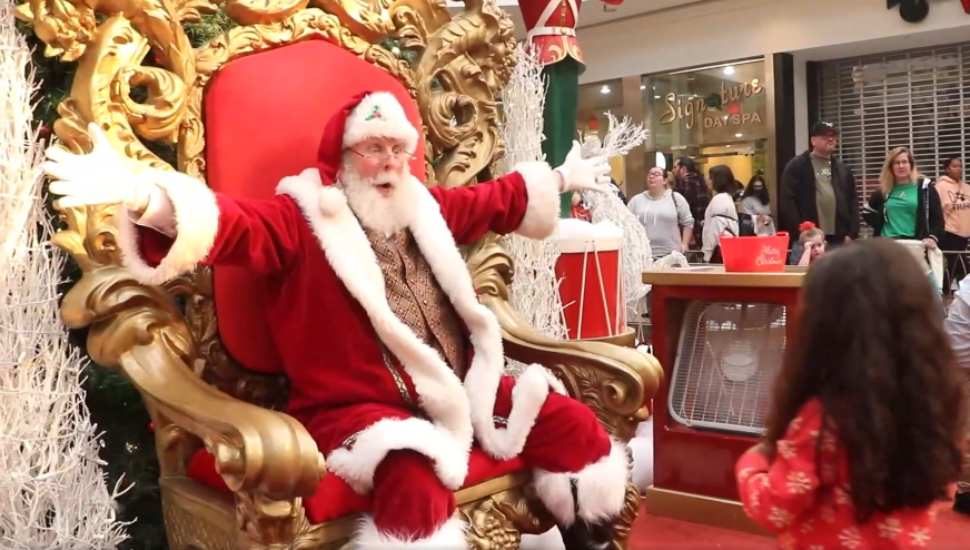 bearded man in a red suit with arms out