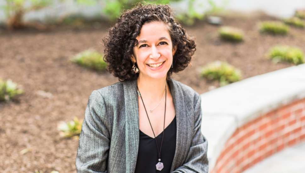 curly haired woman sitting in a garden