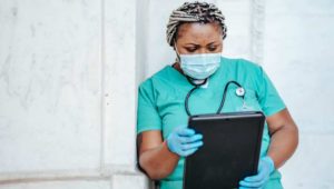 woman in scrubs with tablet