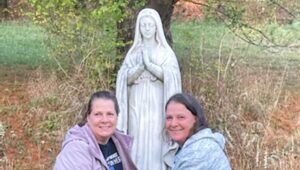 Andrea DiNunzio (left and Angela Wood with St. Cyril Church's statue of Mary.