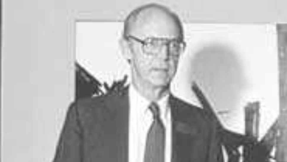 man with dark suit and glasses