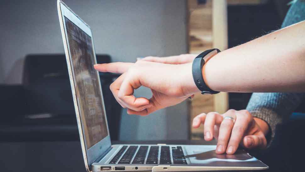 two hands at a laptop