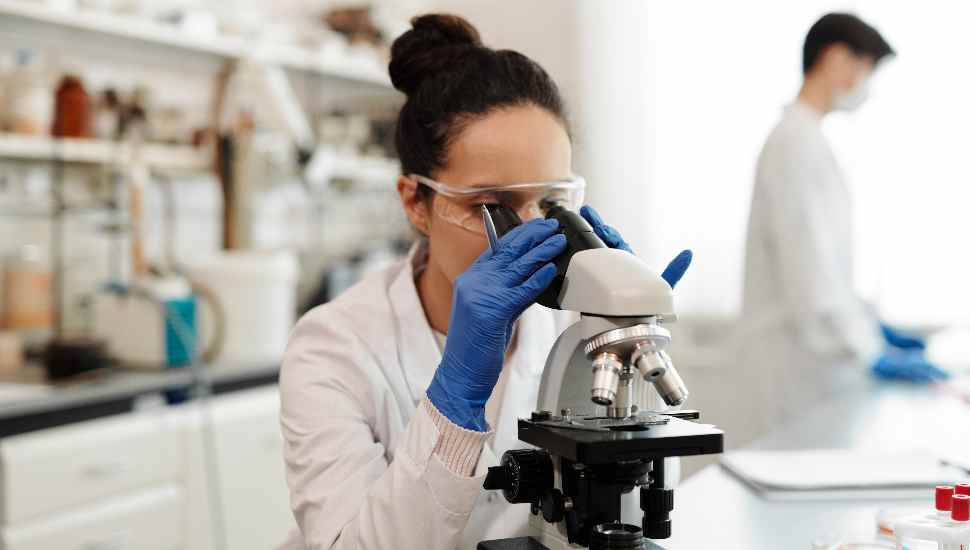 woman peering in microscope
