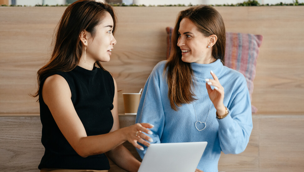 Two women chatting at work
