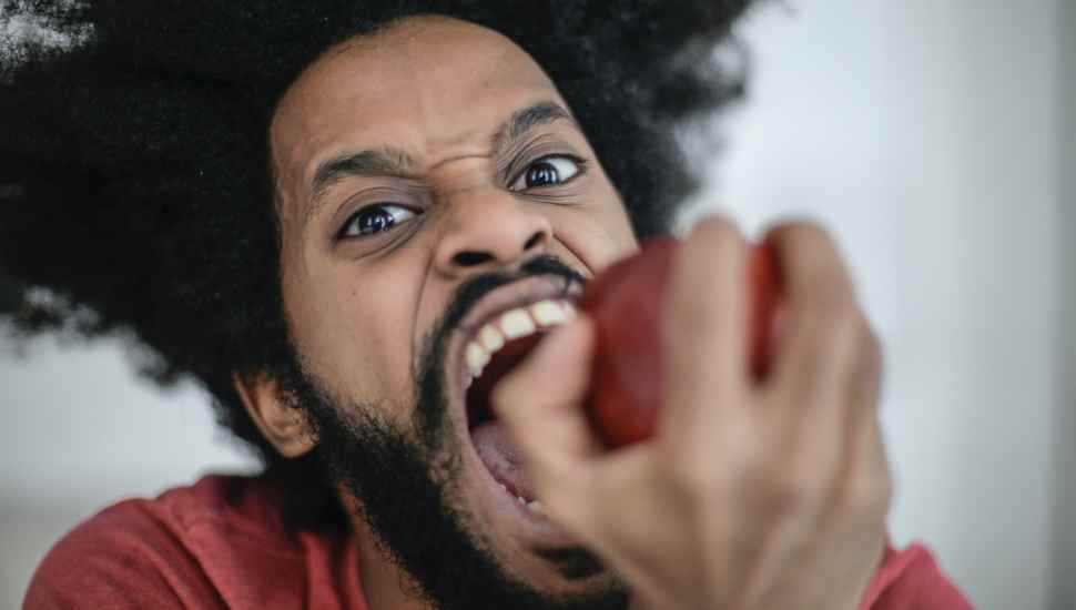 man biting apple