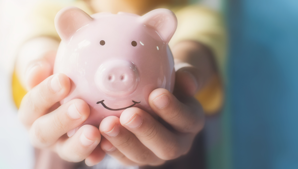 Girl hand holding piggy bank.