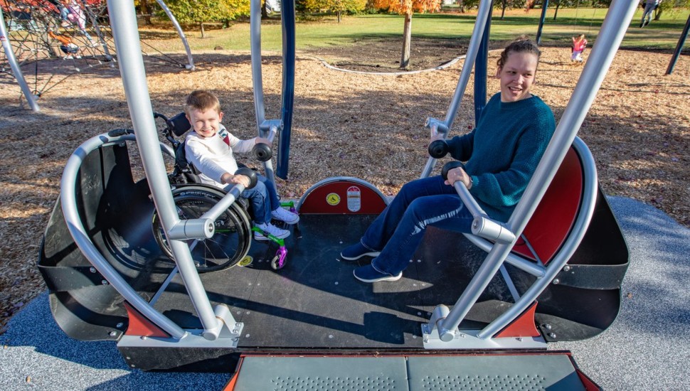A young boy in a wheelchair and a woman on the We-Go-Swing