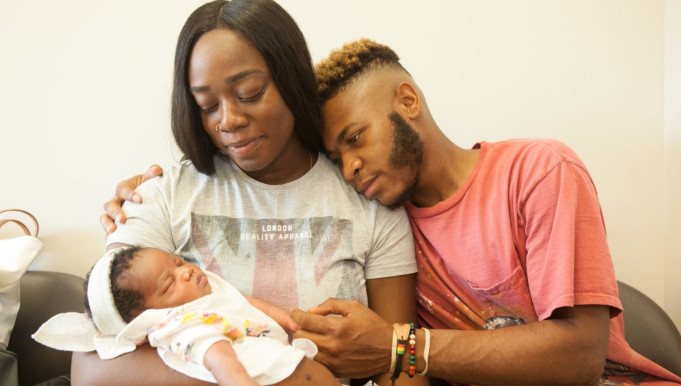 A mother and father with a baby.