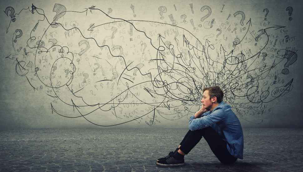 boy sitting by scribbled whiteboard