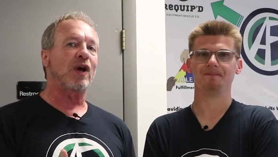 two men in front of a sign