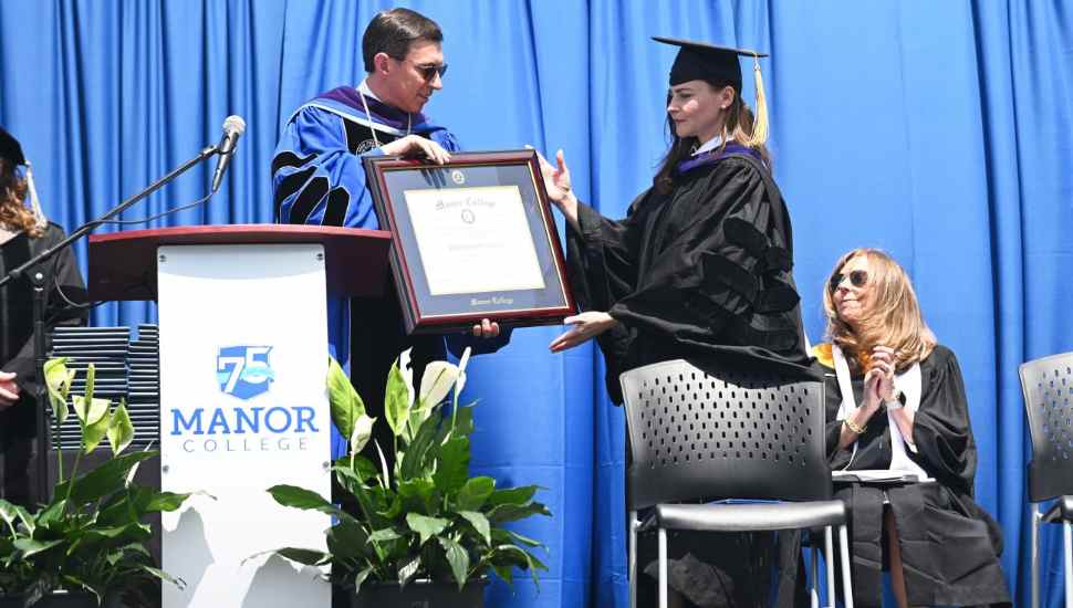 man handing over a framed document