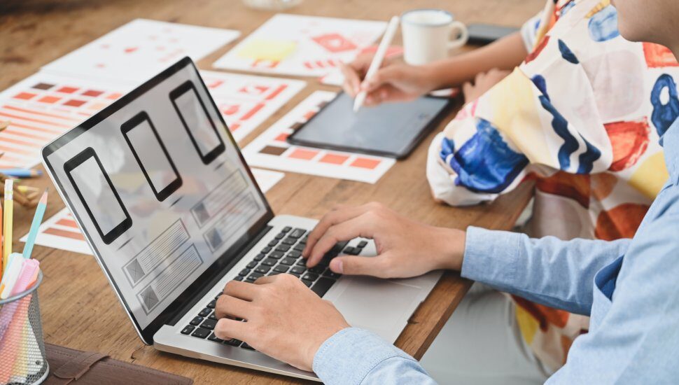 two people using laptop to design website