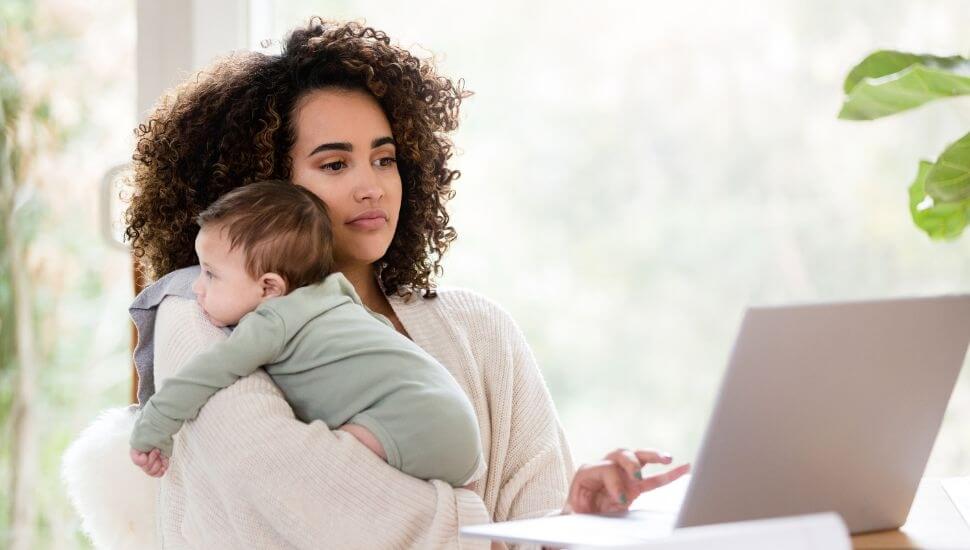 Woman holding a baby while working