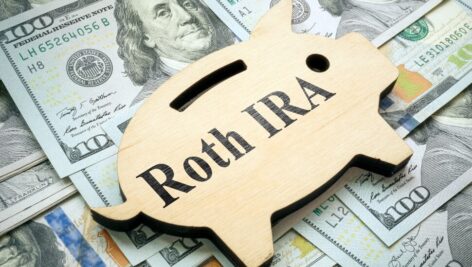Roth IRA on a backdrop of $100 dollar bills