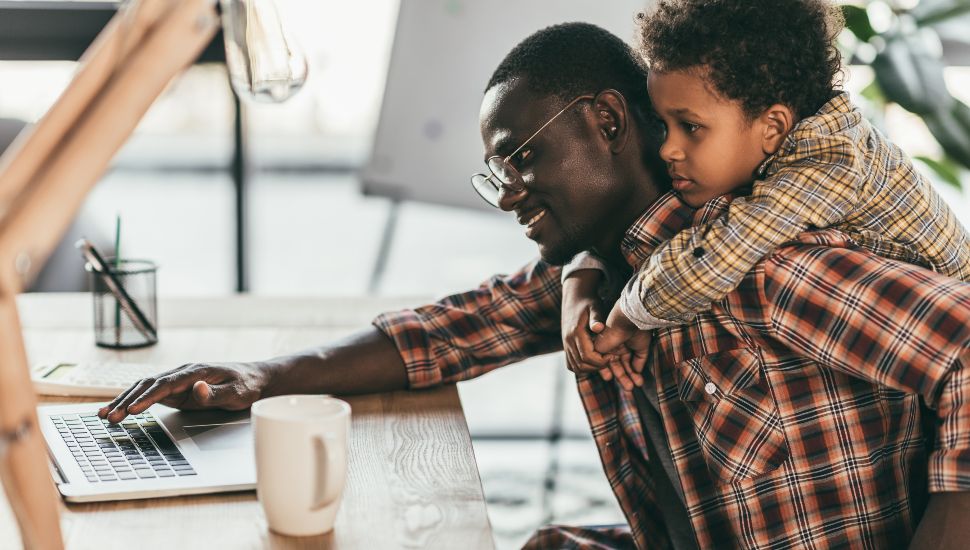 father and son using laptop in office, work life balance