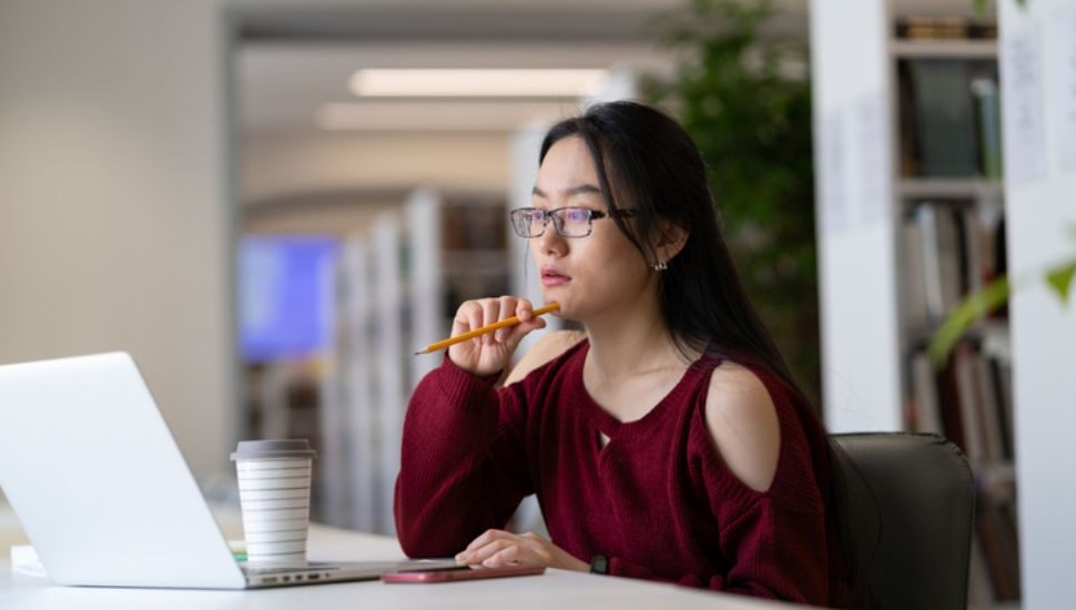 woman at a computer working a green scholarship essay