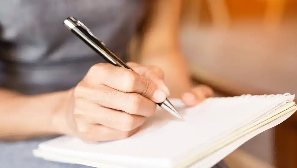 A hand writing in a journal