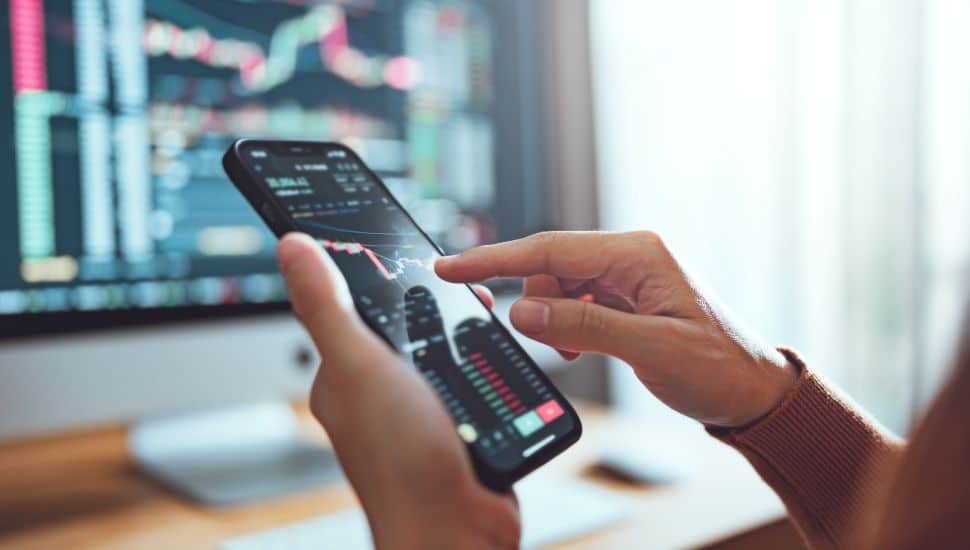 person on cell phone investing
