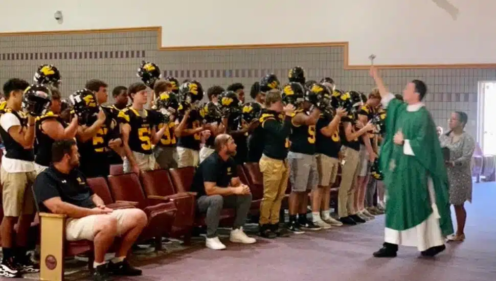 A priest blessing helmets