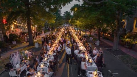 People seated at an outdoor dinner in the streets