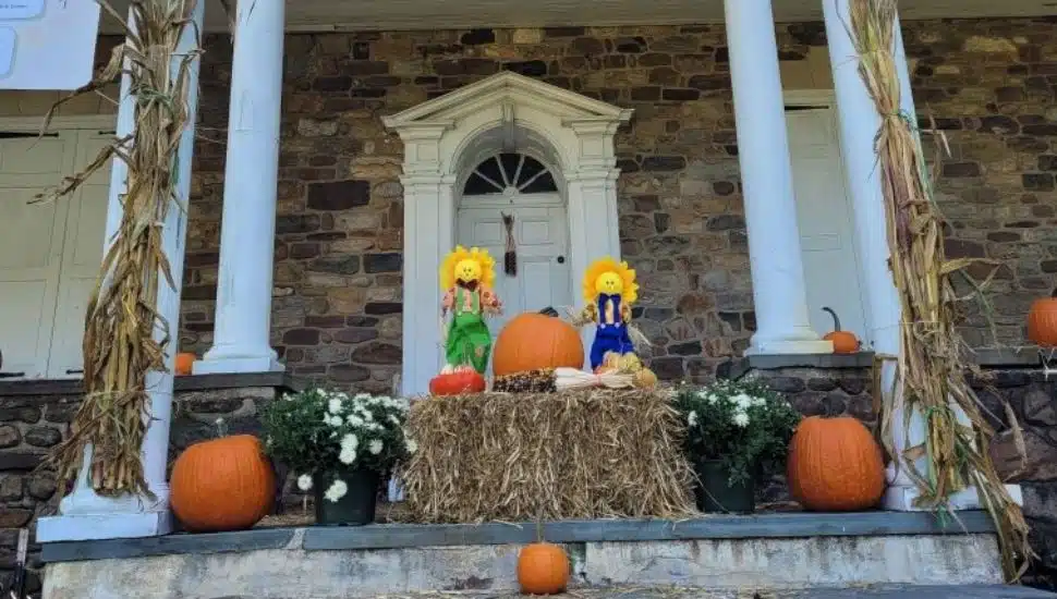 The exterior of the Bolton Mansion with scarecrows and pumpkins