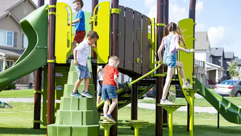 Boys and girls playing on playground equipment .