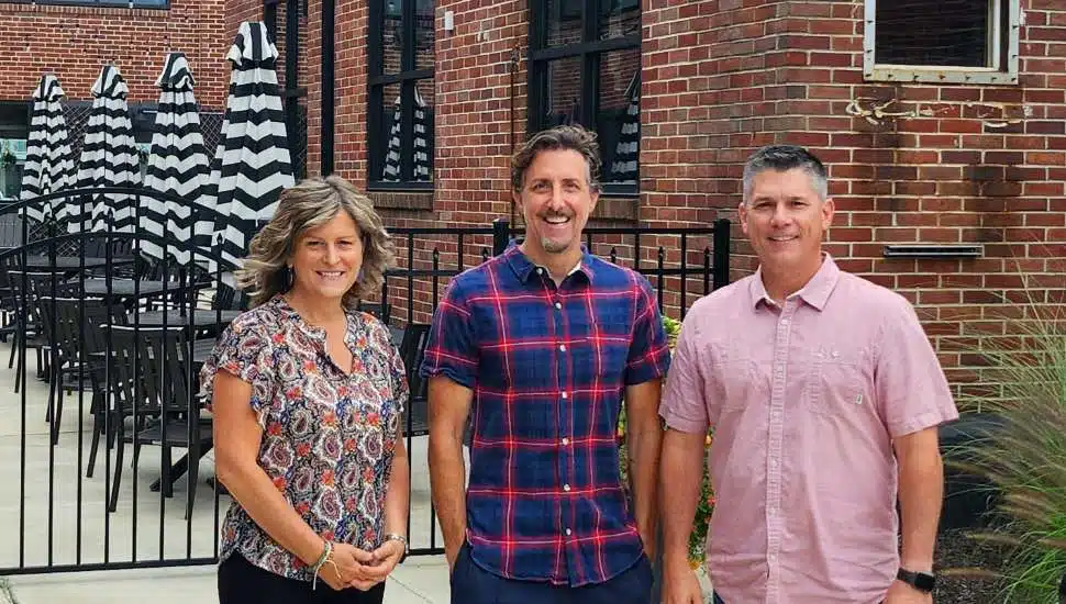 Three people standing next to each other.