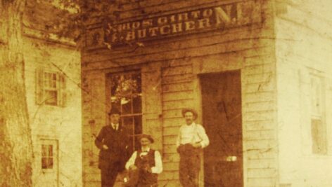 Three men stand outside of the Girton Meat Market