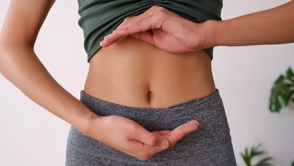 A woman holding her hands around her stomach
