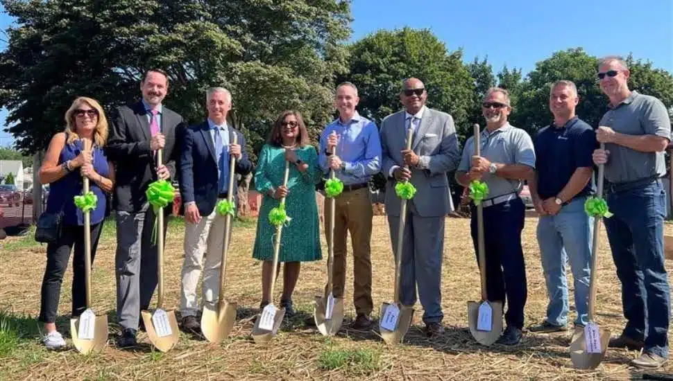 Several politicians standng in a field with shovels
