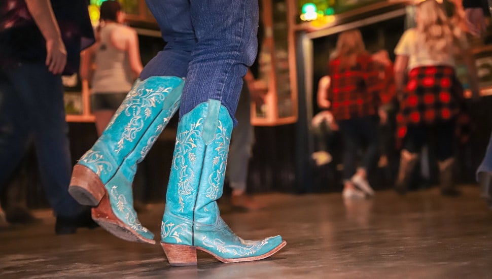 A woman in blue cowboy boots dancing.