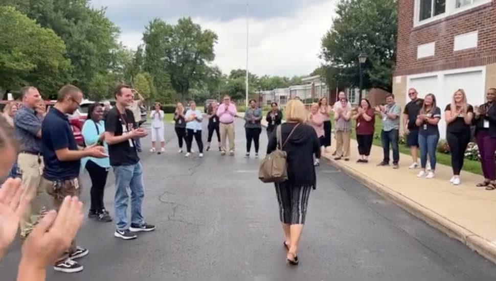 Michelle Spack leaving her office, surrounded by clapping co-workers
