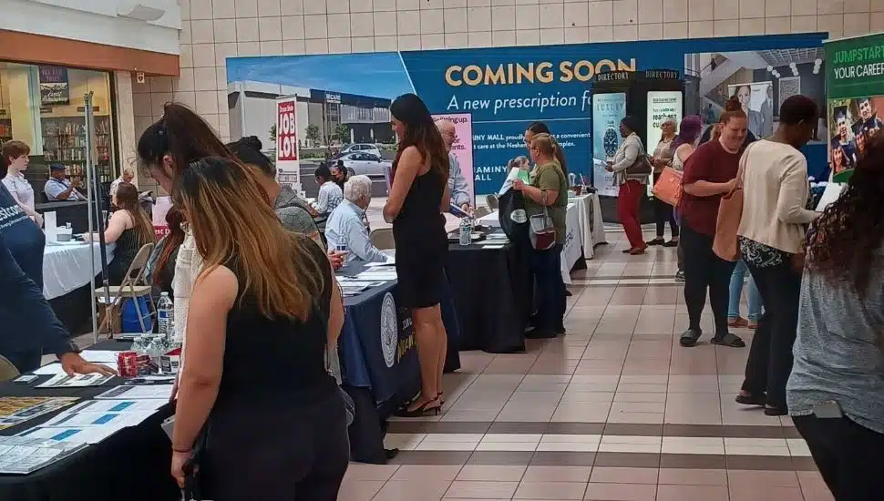 Several people at tables at a job fair