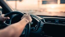 Hands holding a steering wheel in a car