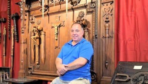Edmondo Crimi sitting with vampire slaying collection in museum