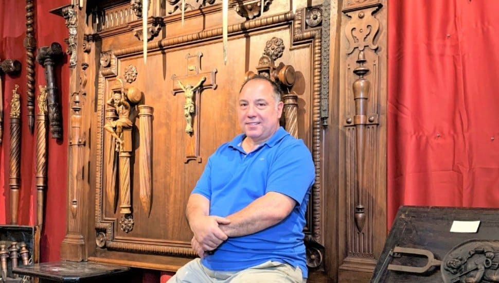 Edmondo Crimi sitting with vampire slaying collection in museum