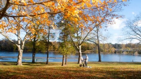 person painting near delaware river in autumnal washington crossing park