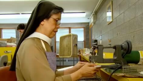 Nun making wafers with machine