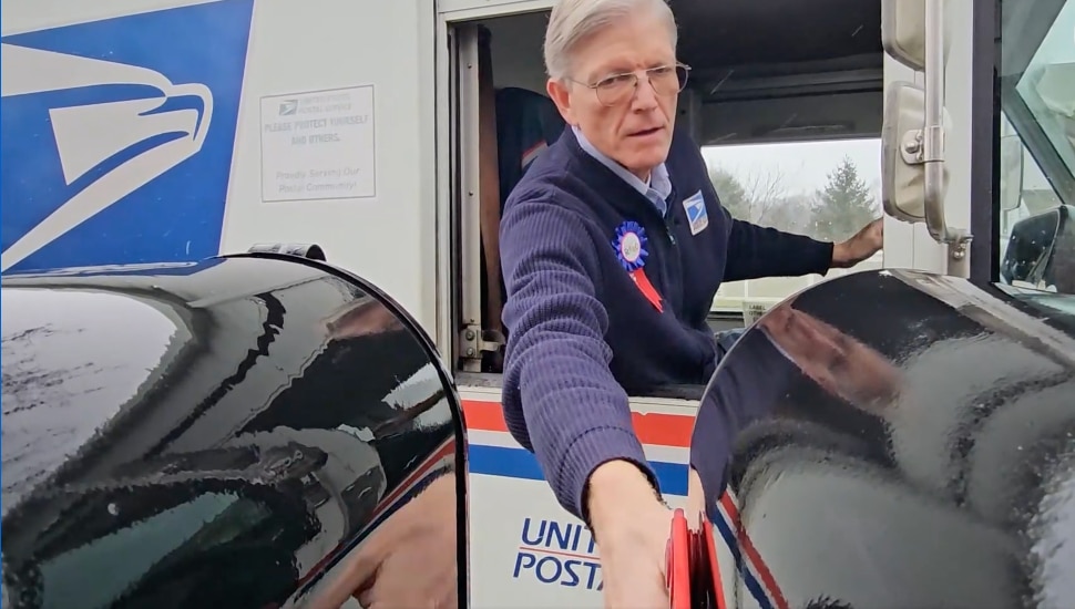 Kyle Livesay delivering mail from truck